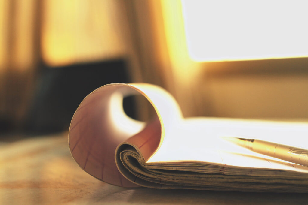 Rolled paper and pen resting on a desk in warm natural light